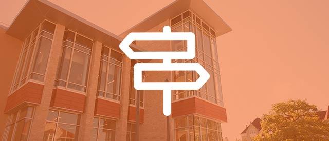 Hastad Hall exterior with directional signage icon